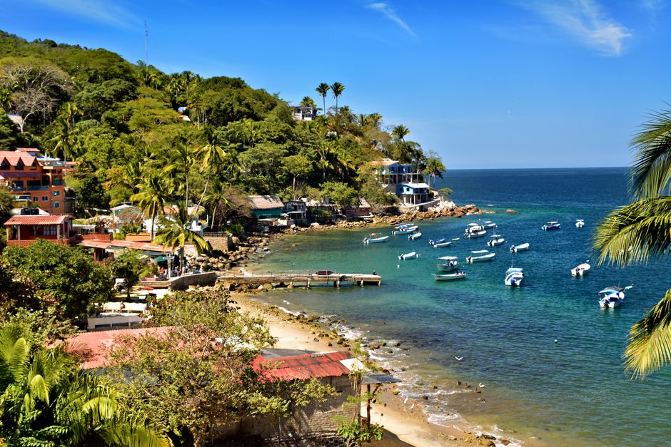 Beautiful coastal scene in Yelapa, Mexico with vibrant boats and lush greenery.