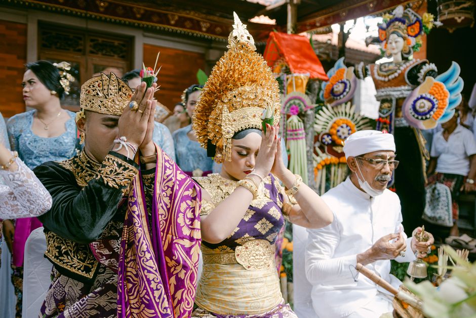 People engaging in a vibrant Hindu ritual in Bali, showcasing traditional attire and offerings.