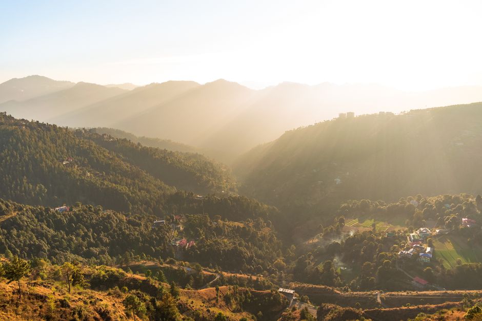 A stunning aerial view of hills and forests at sunset, showcasing nature's beauty.