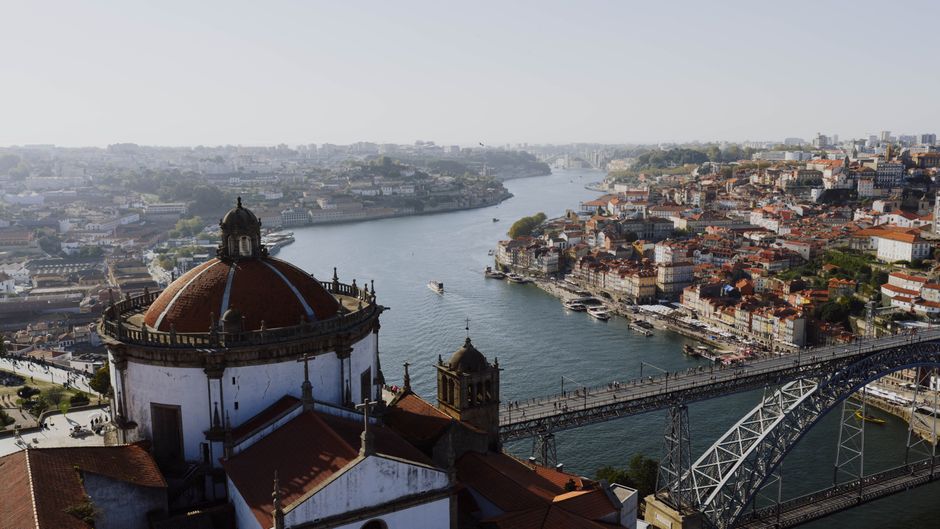 Stunning aerial vista of Porto, Portugal with the Douro River and Dom Luís I Bridge on a sunny day.