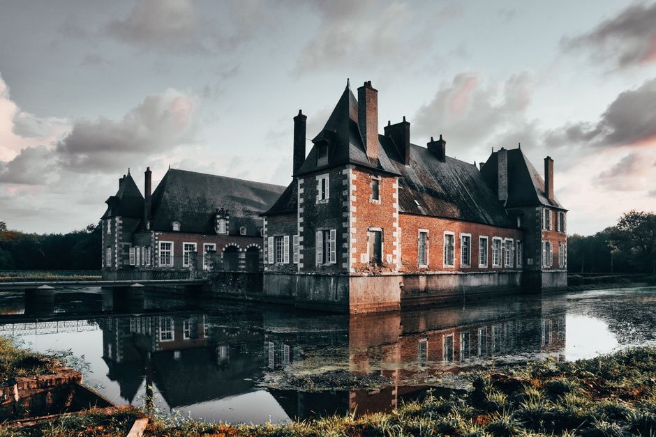 French château reflected in its moat at dusk