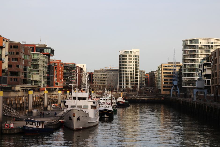 Explore Hamburg's vibrant harbor with modern buildings and moored ships in a serene urban setting.
