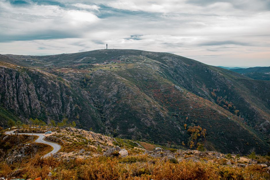 A breathtaking aerial view of the rugged mountain landscape in Aveiro, Portugal, under a cloudy sky.