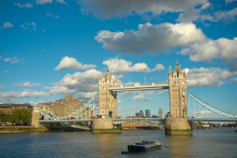 Breathtaking view of Tower Bridge, London, under a sunny blue sky with clouds.