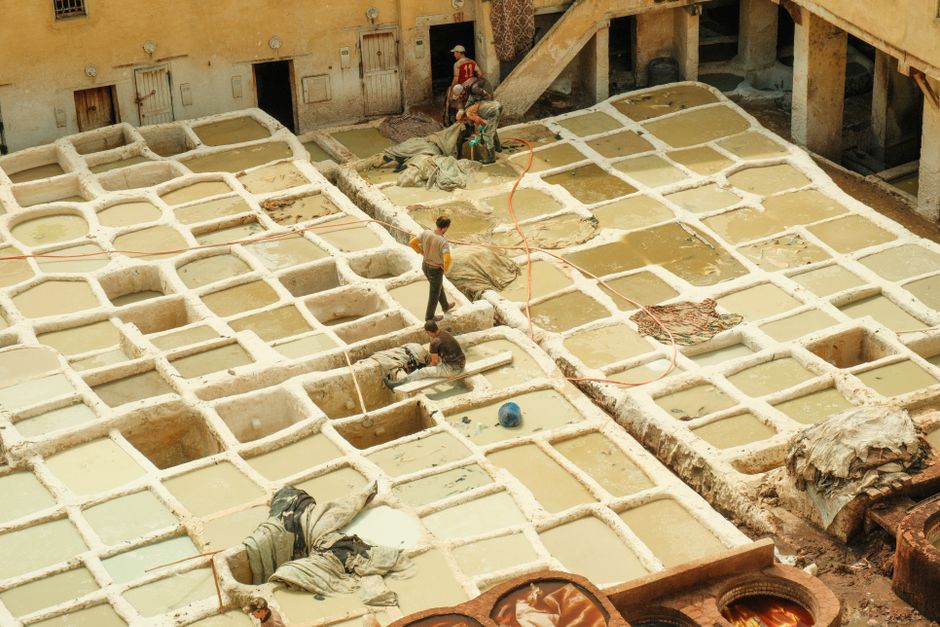 Aerial view of workers in the historic traditional tanneries of Fes, Morocco.