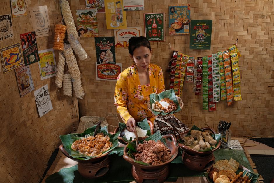 Woman serving traditional Indonesian food at a bamboo stall in Jakarta.