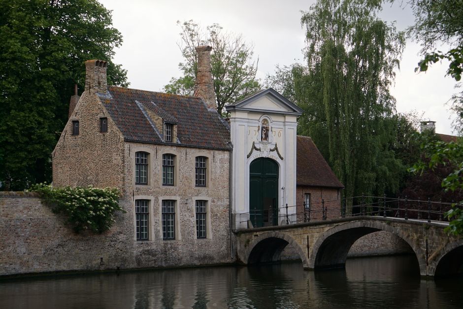 Quaint medieval buildings along the serene canal in Bruges, Belgium, showcasing historic a