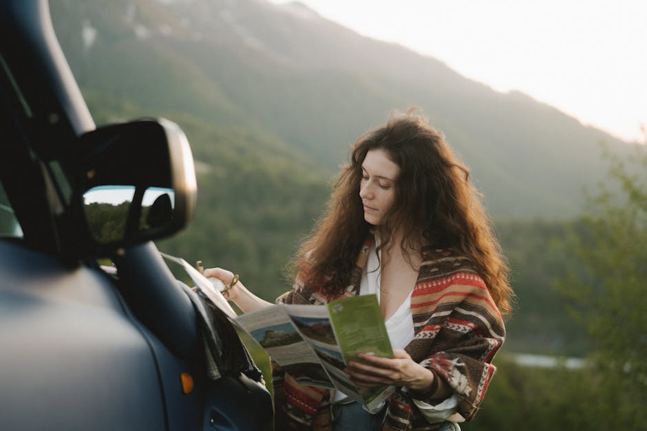 A woman stands by her vehicle using a map to navigate during a scenic road trip. Outdoor travel and exploration.