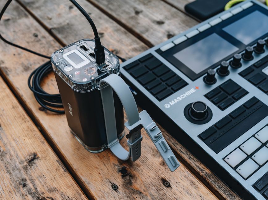 Sound mixer and power supply on a wooden table, ideal for music production setups.