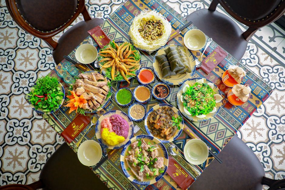 A colorful, traditional Vietnamese feast arranged on an intricately tiled table, showcasing a variety of authentic dishes.
